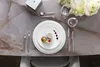 A beautifully set table with a plate of food, cutlery, and glasses. Voir les images du produit