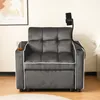 A dark gray sofa bed with white trim, a glass of amber liquid in a cup holder on the left armrest, and a phone holder attached to the right armrest. Produktbild-Vorschau