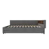 A side view of a grey upholstered daybed with a slatted mattress base and a small wooden shelf unit at one end. Anteprima dell’immagine prodotto