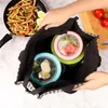 Hands packing food containers into a tote bag, with a pan of pasta and tomatoes in the background. Produktbild-Vorschau