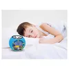 A young boy sleeping in bed next to a Toy Story alarm clock. Voir les images du produit