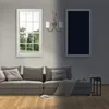 A living room scene with a sofa, window, and a framed picture on the wall, split between light and dark. Produktbild-Vorschau