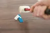 A person is using a rubber mallet to tap leveling clips on a tiled floor. Náhľad obrázku produktu