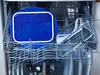 Dishwasher rack with a blue food container and a transparent glass container. Anteprima dell’immagine prodotto