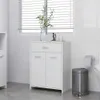 A white bathroom cabinet with a drawer and two doors, placed in a bathroom setting with a window and blinds in the background. Náhled obrázku produktu