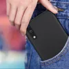 A hand is placing a black smartphone case into the pocket of a pair of blue jeans. Anteprima dell’immagine prodotto