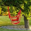 A striped hammock chair hangs from a tree in a grassy yard. Náhled obrázku produktu