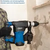 A person is using a blue and black rotary hammer drill to drill into a concrete wall. Podgląd zdjęcia produktu
