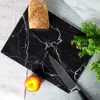 A black marble cutting board with white veining, featuring a loaf of bread, an apple, and a knife. Náhľad obrázku produktu
