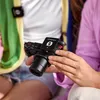 A person is holding a camera with a wireless microphone attached. Anteprima dell’immagine prodotto