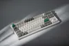 A mechanical keyboard is shown on a gray surface with dramatic lighting. Produktbild-Vorschau
