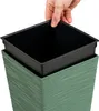 A hand is placing a black inner pot into a green planter. Anteprima dell’immagine prodotto