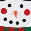 Close-up of a snowman's face with black button eyes, red cheek circles, and an orange carrot nose. A green and red striped scarf is visible at the bottom. Náhľad obrázku produktu