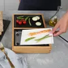 A person is placing a plate of food onto a table grill. Produktbild-Vorschau