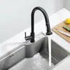 A black kitchen faucet with water running into a stainless steel sink. Náhled obrázku produktu