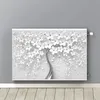 A radiator cover with a 3D white flower design is mounted on a gray wall above a wooden floor. Anteprima dell’immagine prodotto