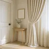 A corner of a room with a door, a small table with a vase of greenery, and a beige curtain. Produktbild-Vorschau