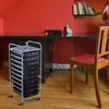 A multi-drawer rolling cart sits next to a desk in a room with red walls and a wooden floor. Anteprima dell’immagine prodotto
