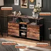 A media console or storage cabinet with a rustic wood finish and black metal frame, displayed in a room setting with decorative items. Podgląd zdjęcia produktu