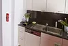 A kitchen scene with a fire extinguisher mounted on the wall. Produktbild-Vorschau