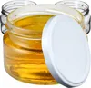 Three glass jars filled with a golden liquid, one with a white lid. Podgląd zdjęcia produktu