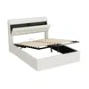 A white upholstered bed frame with its mattress support mechanism lifted to reveal storage space underneath. Produktbild-Vorschau