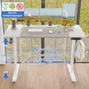 A white and gray height-adjustable desk with multiple monitors set up in a home office or office environment, with a window in the background showing trees and foliage. Anteprima dell’immagine prodotto