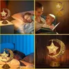 A collage of four images showing a decorative moon and star lamp in different settings, including a child sleeping, a mother reading to a child, and a close-up of the lamp. Produktbild-Vorschau