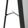 A close-up view of the hinge mechanism connecting the legs of a black stand mirror. Náhled obrázku produktu