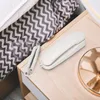 A white corded telephone rests on a light wood nightstand next to a bed with a gray and white zigzag patterned blanket. Náhled obrázku produktu