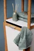 A bathroom shelf with towels and a diffuser. Produktbild-Vorschau