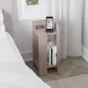 A bedside table with a phone and glasses on top, and books on the shelf, next to a bed. Podgląd zdjęcia produktu