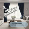 A living room scene with a sofa, coffee table, and curtains, featuring a close-up of curtain rods. Produktbild-Vorschau