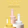 Three cartoon chicken-style mini desktop vacuum cleaners in yellow, pink, and white are displayed on pedestals against a yellow background. Produktbild-Vorschau