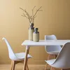 A dining table with chairs and decorative vases in a room with yellow walls. Anteprima dell’immagine prodotto