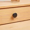 A close-up view of a wooden drawer with a black knob. Produktbild-Vorschau
