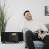 A man relaxing on a couch while listening to a DAB radio. Produktbild-Vorschau