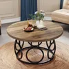 A round coffee table with a wood-grain top and a black metal base, placed on a jute rug in a living room setting. Podgląd zdjęcia produktu