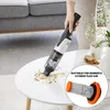 A person is using a handheld vacuum cleaner to clean up debris from a white table. A close-up of a filter is shown in a circle on the right side of the image. Produktbild-Vorschau