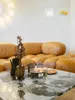 A living room scene with a large sectional sofa and a marble coffee table. Produktbild-Vorschau