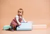 A baby girl is playing with colorful foam blocks. Podgląd zdjęcia produktu