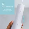 A hand holding a white water flosser with a blue overlay showing text. Produktbild-Vorschau