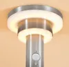 A close-up view of a modern, metallic outdoor light fixture with integrated LED lighting and a motion sensor. Produktbild-Vorschau
