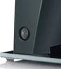 A close-up view of the side of a dark gray appliance, showing a black power switch with a white 'O' and '-' symbol, resting on a clear glass base with small clear feet. Anteprima dell’immagine prodotto