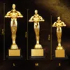 Three golden trophies of different sizes are displayed on a dark brown background. Produktbild-Vorschau
