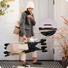 A woman is carrying a folded stroller outside a doorway. Voir les images du produit