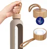A hand holding a water bottle with a bamboo lid and a separate shot of the lid and a bamboo icon. Produktbild-Vorschau
