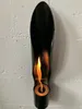A black ethanol fireplace mounted on a white brick wall. Produktbild-Vorschau