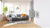 A living room with a sofa, coffee tables, and a TV mounted on the wall. Voir les images du produit