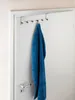 A blue towel hanging on a silver over-the-door hook organizer attached to a white door. Produktbild-Vorschau